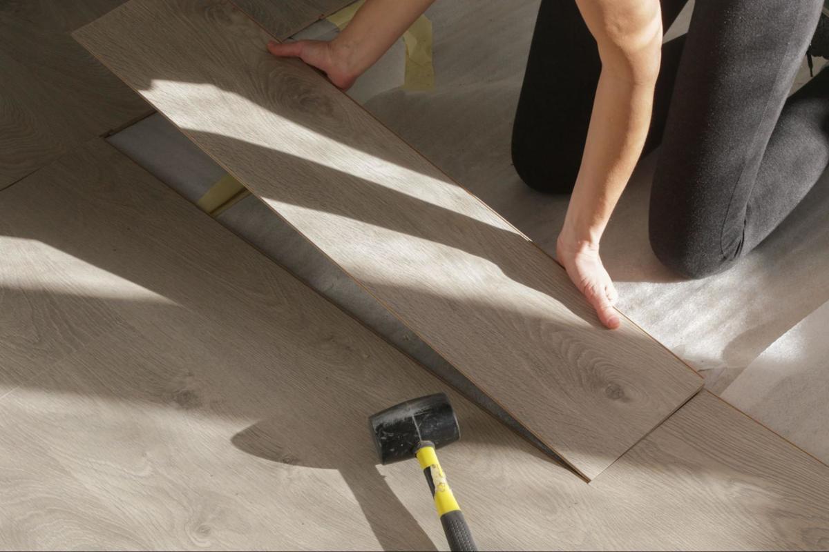 Vakman plaatst laminaatplank nauwkeurig voor een strak en stabiel resultaat